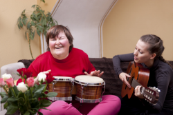 a girl and a disabled person are happily playing musical instruments